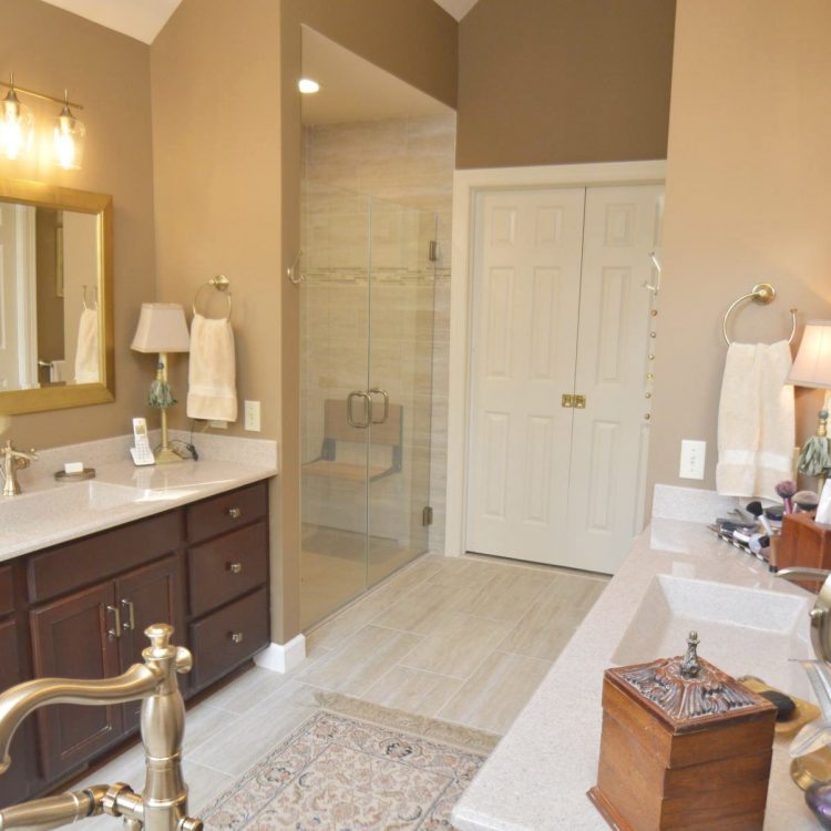 Fairway (9) A remodeled bathroom with marble countertops, a large mirror in front of the sink and a walk in shower