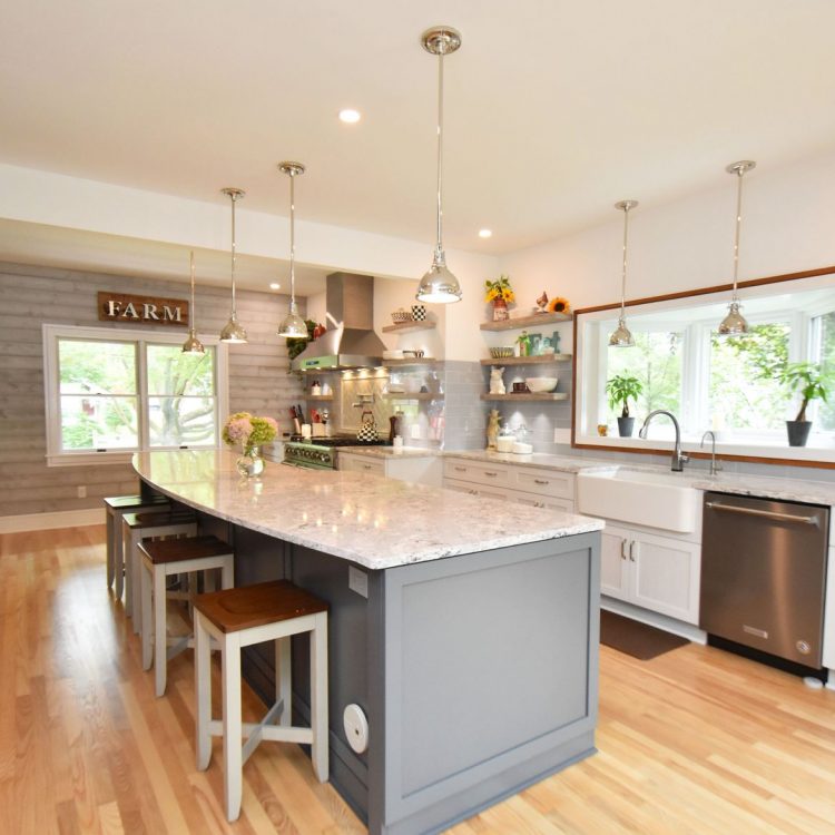 Five mile line road (1) A kitchen remodeled with grey backsplash and a granite countertop island. There is a bay window behind the kitchen sink